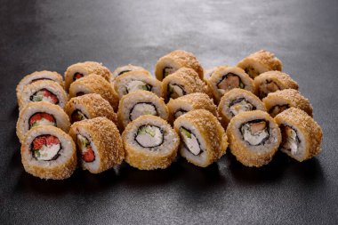 Karanlık bir arka planda taze, lezzetli suşi ruloları. Japon mutfağının elementleri