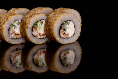 Karanlık bir arka planda taze, lezzetli suşi ruloları. Japon mutfağının elementleri