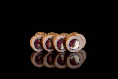 Karanlık bir arka planda taze, lezzetli suşi ruloları. Japon mutfağının elementleri