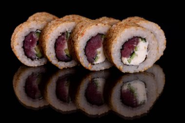 Karanlık bir arka planda taze, lezzetli suşi ruloları. Japon mutfağının elementleri