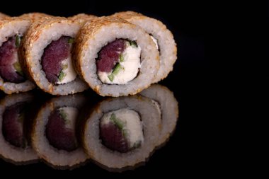 Karanlık bir arka planda taze, lezzetli suşi ruloları. Japon mutfağının elementleri