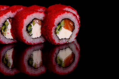 Karanlık bir arka planda taze, lezzetli suşi ruloları. Japon mutfağının elementleri