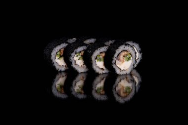 Karanlık bir arka planda taze, lezzetli suşi ruloları. Japon mutfağının elementleri