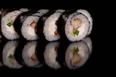 Karanlık bir arka planda taze, lezzetli suşi ruloları. Japon mutfağının elementleri