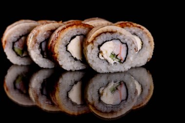 Karanlık bir arka planda taze, lezzetli suşi ruloları. Japon mutfağının elementleri