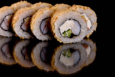Karanlık bir arka planda taze, lezzetli suşi ruloları. Japon mutfağının elementleri