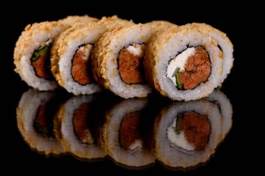 Karanlık bir arka planda taze, lezzetli suşi ruloları. Japon mutfağının elementleri