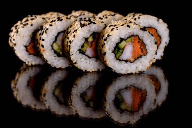 Karanlık bir arka planda taze, lezzetli suşi ruloları. Japon mutfağının elementleri