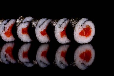 Karanlık bir arka planda taze, lezzetli suşi ruloları. Japon mutfağının elementleri