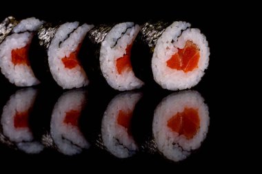 Karanlık bir arka planda taze, lezzetli suşi ruloları. Japon mutfağının elementleri