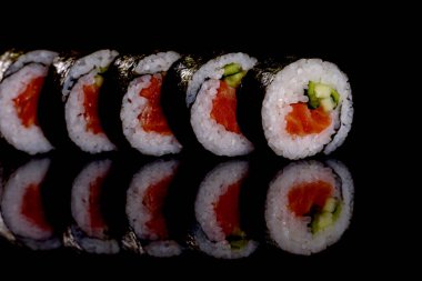 Karanlık bir arka planda taze, lezzetli suşi ruloları. Japon mutfağının elementleri