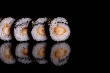 Karanlık bir arka planda taze, lezzetli suşi ruloları. Japon mutfağının elementleri