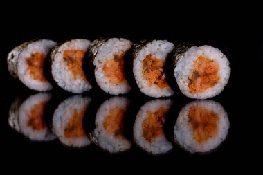 Karanlık bir arka planda taze, lezzetli suşi ruloları. Japon mutfağının elementleri