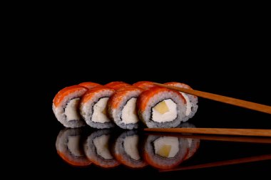 Karanlık bir arka planda taze, lezzetli suşi ruloları. Japon mutfağının elementleri