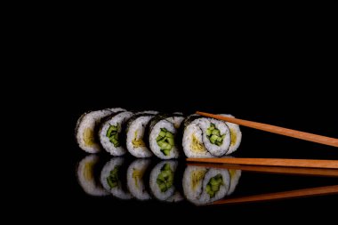 Karanlık bir arka planda taze, lezzetli suşi ruloları. Japon mutfağının elementleri