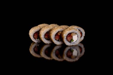 Karanlık bir arka planda taze, lezzetli suşi ruloları. Japon mutfağının elementleri