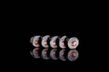 Karanlık bir arka planda taze, lezzetli suşi ruloları. Japon mutfağının elementleri