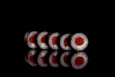 Karanlık bir arka planda taze, lezzetli suşi ruloları. Japon mutfağının elementleri