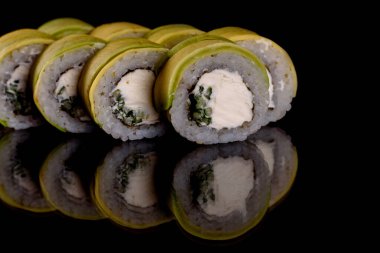 Karanlık bir arka planda taze, lezzetli suşi ruloları. Japon mutfağının elementleri