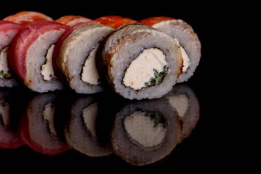 Karanlık bir arka planda taze, lezzetli suşi ruloları. Japon mutfağının elementleri