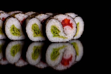Karanlık bir arka planda taze, lezzetli suşi ruloları. Japon mutfağının elementleri