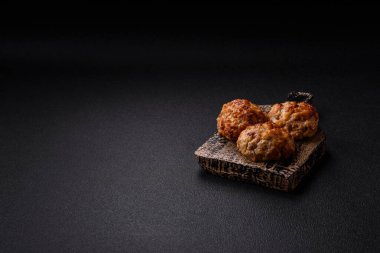 Lezzetli taze kıymalı balık pirzolası. Esmer arka planda baharatlar ve otlarla birlikte.