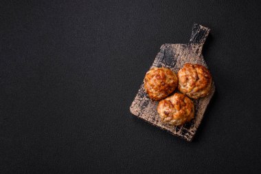 Lezzetli taze kıymalı balık pirzolası. Esmer arka planda baharatlar ve otlarla birlikte.