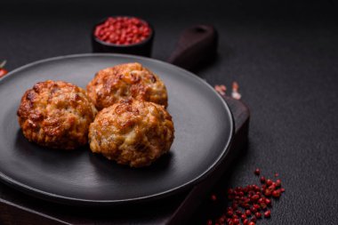 Lezzetli taze kıymalı balık pirzolası. Esmer arka planda baharatlar ve otlarla birlikte.