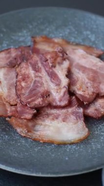 Lezzetli bir İngiliz kahvaltısının malzemesi olarak kızarmış domuz pastırması. Tasarımın için arka plan olarak kızarmış pastırma parçaları.