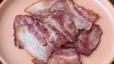 Lezzetli bir İngiliz kahvaltısının malzemesi olarak kızarmış domuz pastırması. Tasarımın için arka plan olarak kızarmış pastırma parçaları.