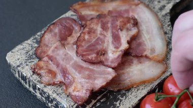 Lezzetli bir İngiliz kahvaltısının malzemesi olarak kızarmış domuz pastırması. Tasarımın için arka plan olarak kızarmış pastırma parçaları.