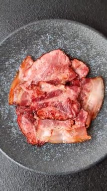 Lezzetli bir İngiliz kahvaltısının malzemesi olarak kızarmış domuz pastırması. Tasarımın için arka plan olarak kızarmış pastırma parçaları.