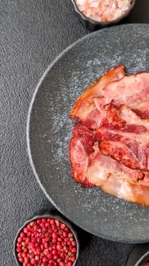 Lezzetli bir İngiliz kahvaltısının malzemesi olarak kızarmış domuz pastırması. Tasarımın için arka plan olarak kızarmış pastırma parçaları.