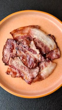 Lezzetli bir İngiliz kahvaltısının malzemesi olarak kızarmış domuz pastırması. Tasarımın için arka plan olarak kızarmış pastırma parçaları.