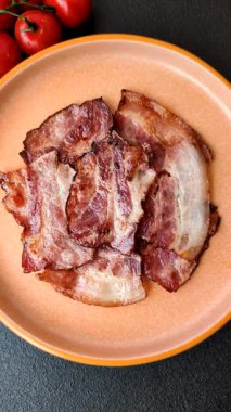 Lezzetli bir İngiliz kahvaltısının malzemesi olarak kızarmış domuz pastırması. Tasarımın için arka plan olarak kızarmış pastırma parçaları.