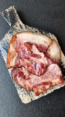 Lezzetli bir İngiliz kahvaltısının malzemesi olarak kızarmış domuz pastırması. Tasarımın için arka plan olarak kızarmış pastırma parçaları.