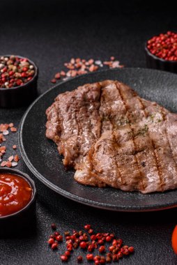 Izgara biftek, barbeküde tuzlu ve biberli et. Yemek arkaplanı olarak ızgara biftek.