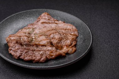 Izgara biftek, barbeküde tuzlu ve biberli et. Yemek arkaplanı olarak ızgara biftek.