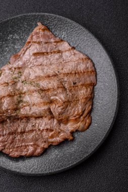 Izgara biftek, barbeküde tuzlu ve biberli et. Yemek arkaplanı olarak ızgara biftek.