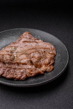 Izgara biftek, barbeküde tuzlu ve biberli et. Yemek arkaplanı olarak ızgara biftek.