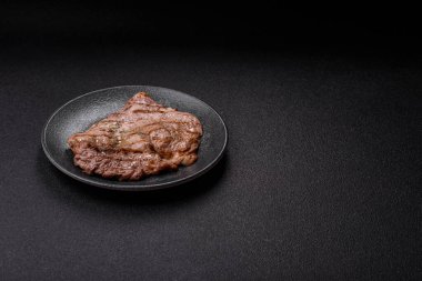 Izgara biftek, barbeküde tuzlu ve biberli et. Yemek arkaplanı olarak ızgara biftek.