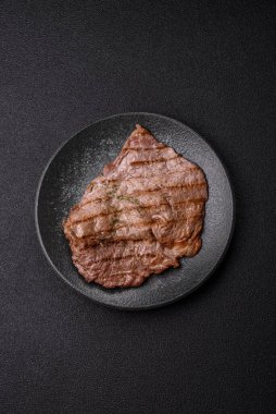 Izgara biftek, barbeküde tuzlu ve biberli et. Yemek arkaplanı olarak ızgara biftek.
