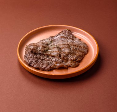 Izgara biftek, barbeküde tuzlu ve biberli et. Yemek arkaplanı olarak ızgara biftek.