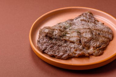 Izgara biftek, barbeküde tuzlu ve biberli et. Yemek arkaplanı olarak ızgara biftek.