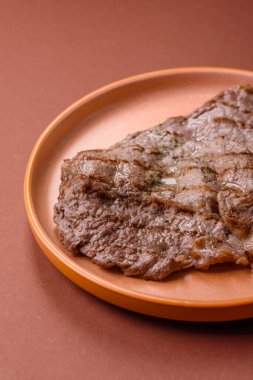 Izgara biftek, barbeküde tuzlu ve biberli et. Yemek arkaplanı olarak ızgara biftek.