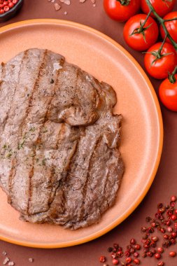 Izgara biftek, barbeküde tuzlu ve biberli et. Yemek arkaplanı olarak ızgara biftek.