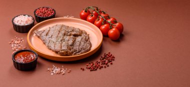 Izgara biftek, barbeküde tuzlu ve biberli et. Yemek arkaplanı olarak ızgara biftek.