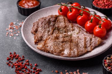 Izgara biftek, barbeküde tuzlu ve biberli et. Yemek arkaplanı olarak ızgara biftek.