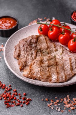 Izgara biftek, barbeküde tuzlu ve biberli et. Yemek arkaplanı olarak ızgara biftek.