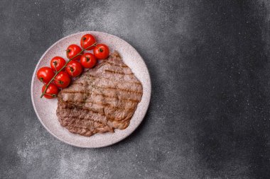 Izgara biftek, barbeküde tuzlu ve biberli et. Yemek arkaplanı olarak ızgara biftek.